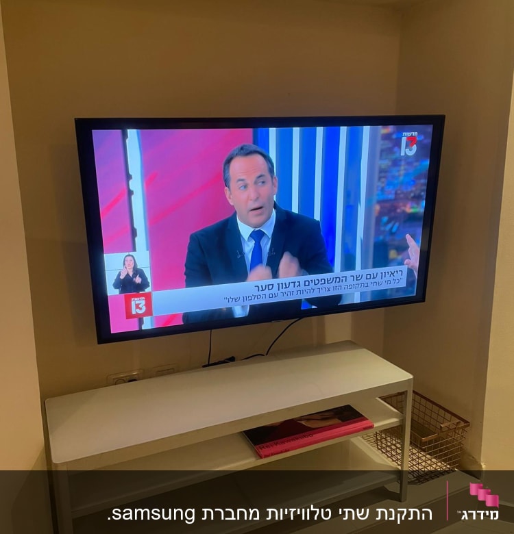 טלוויזיה תלויה על הקיר מעל מדף עם חוטים